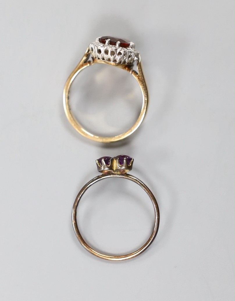 A continental yellow metal, garnet and diamond chip set oval cluster ring, size K and a small Victorian yellow metal, two stone cabochon amethyst and three stone rose cut diamond set cluster ring, size M, gross weight 4.